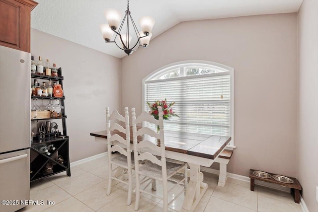 tiled dining room with a notable chandelier and lofted ceiling