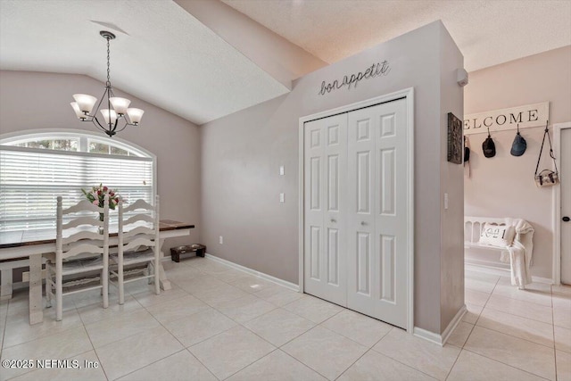 tiled dining area featuring a chandelier and lofted ceiling