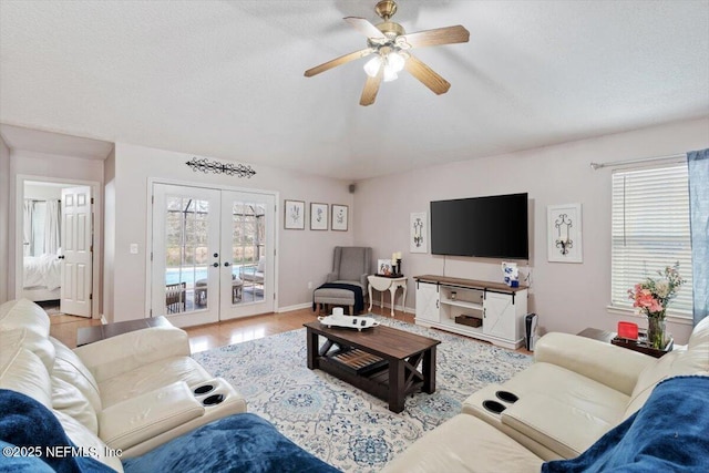 living room with hardwood / wood-style floors, a healthy amount of sunlight, a textured ceiling, and french doors