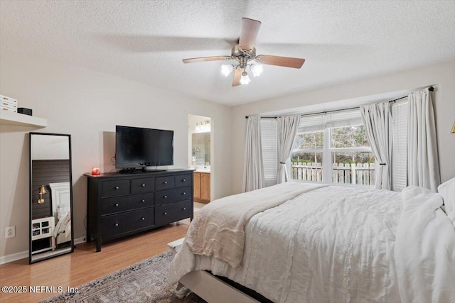 bedroom with ceiling fan, a textured ceiling, ensuite bathroom, and light wood-type flooring