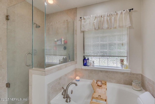 bathroom featuring a textured ceiling and independent shower and bath