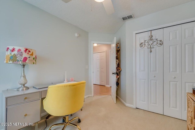 office area with ceiling fan, light colored carpet, and a textured ceiling