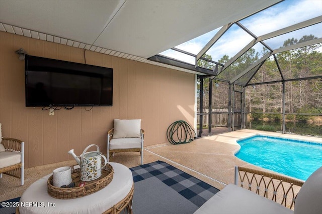 view of pool with glass enclosure and a patio area