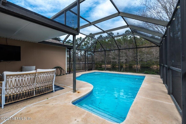 view of swimming pool with glass enclosure and a patio area