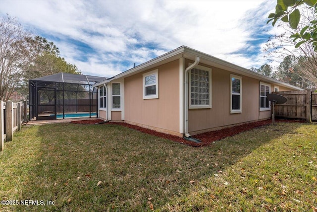 view of home's exterior featuring a lanai, a fenced in pool, and a yard