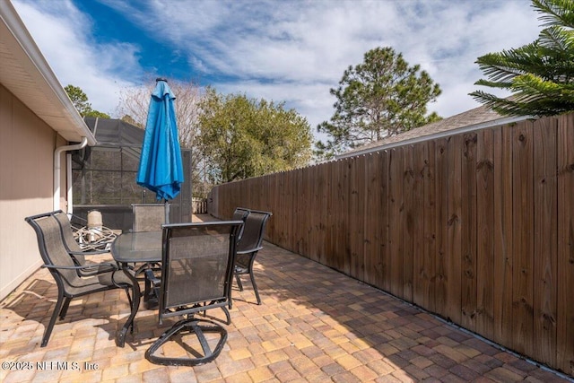 view of patio featuring a lanai