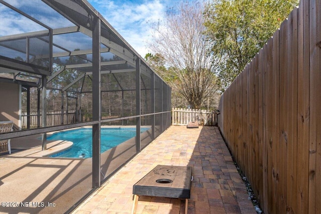 view of pool with glass enclosure and a patio area