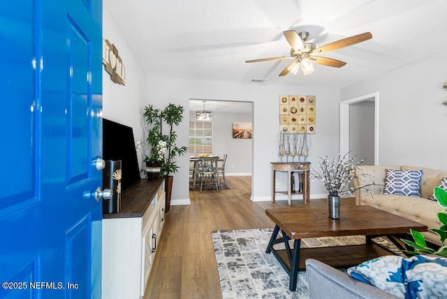 living room featuring wood-type flooring and ceiling fan