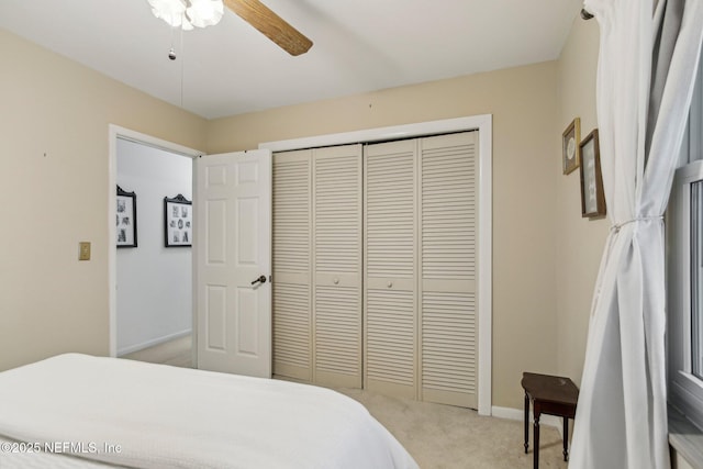 carpeted bedroom with ceiling fan and a closet