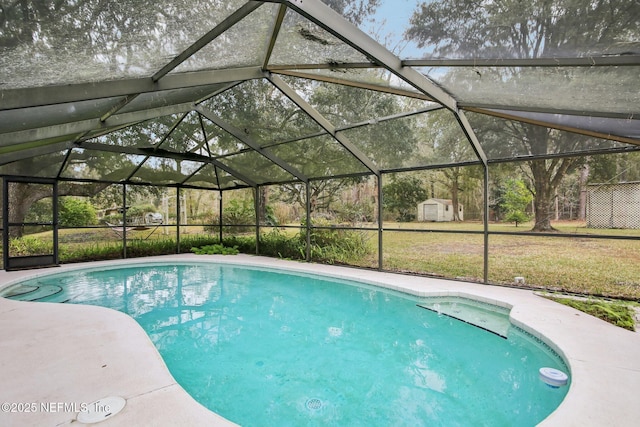 view of pool with a lanai, a yard, and a storage unit