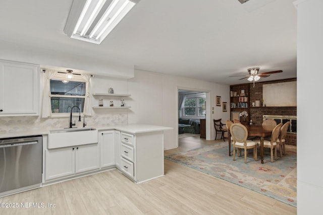 kitchen with dishwasher, sink, white cabinets, and kitchen peninsula