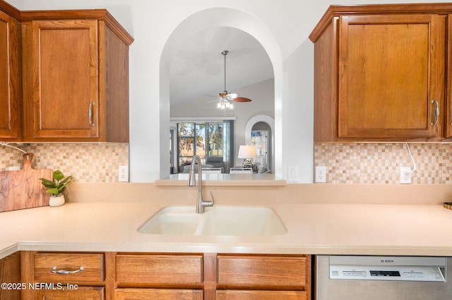 kitchen with dishwasher, vaulted ceiling, sink, and backsplash