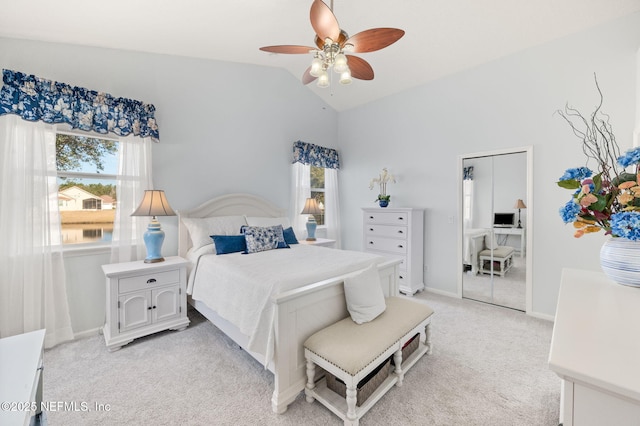 bedroom featuring vaulted ceiling, light carpet, and ceiling fan