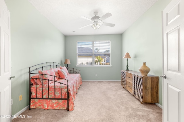 carpeted bedroom featuring a textured ceiling and ceiling fan