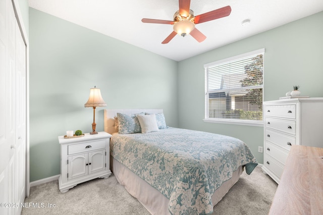 carpeted bedroom featuring ceiling fan and a closet