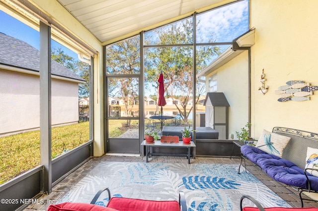 sunroom featuring lofted ceiling and plenty of natural light