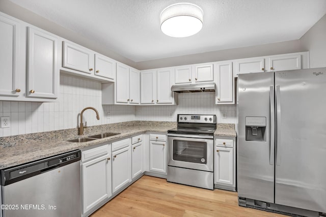 kitchen featuring stainless steel appliances, sink, white cabinets, and light hardwood / wood-style flooring