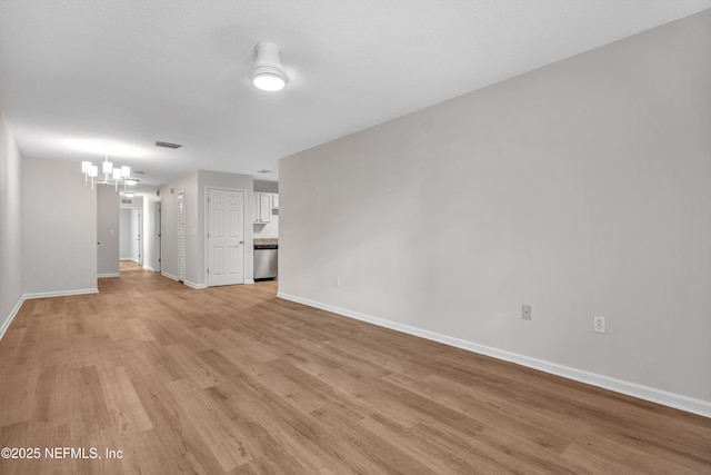 unfurnished living room featuring a chandelier and light hardwood / wood-style flooring