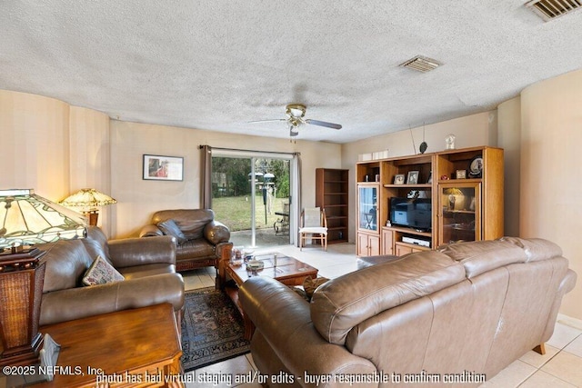 living room featuring light tile patterned floors, a textured ceiling, and ceiling fan