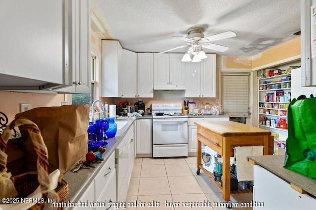 kitchen featuring sink, white appliances, white cabinets, and light tile patterned flooring