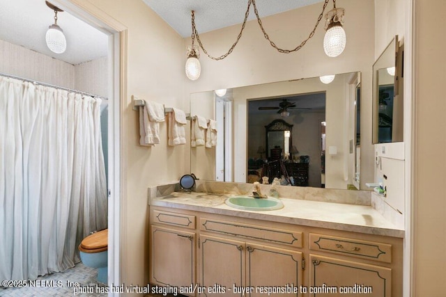 bathroom featuring ceiling fan, vanity, toilet, and a textured ceiling