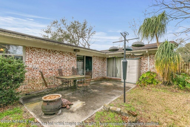 back of property featuring a patio area and an outdoor fire pit