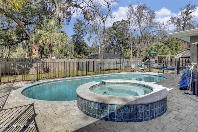 view of swimming pool with an in ground hot tub and a playground