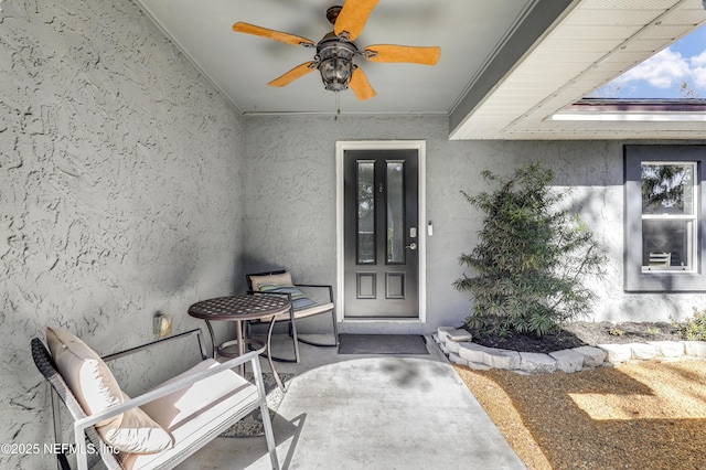 view of exterior entry featuring a patio and ceiling fan