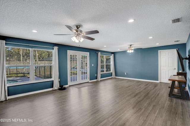 unfurnished living room featuring dark hardwood / wood-style floors, a textured ceiling, ceiling fan, and french doors