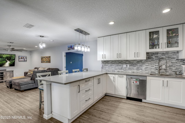 kitchen featuring pendant lighting, white cabinets, sink, and dishwasher