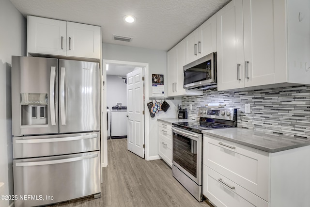 kitchen featuring white cabinetry, backsplash, and appliances with stainless steel finishes