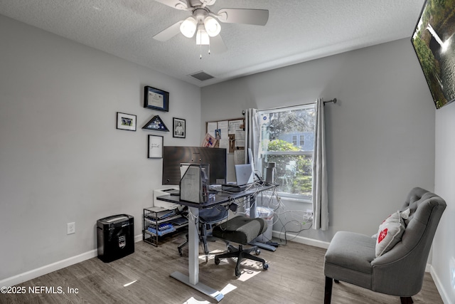 home office with ceiling fan, a textured ceiling, and light wood-type flooring