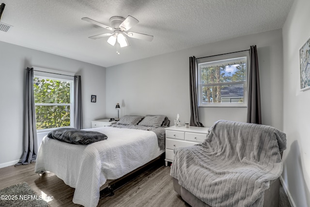 bedroom featuring ceiling fan, a textured ceiling, and light hardwood / wood-style flooring