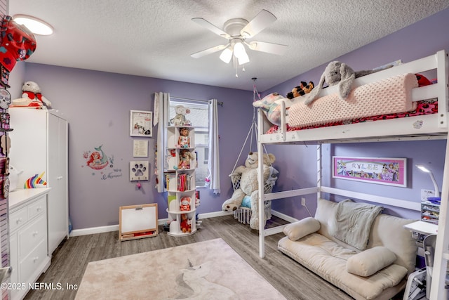 bedroom with ceiling fan, dark hardwood / wood-style floors, and a textured ceiling