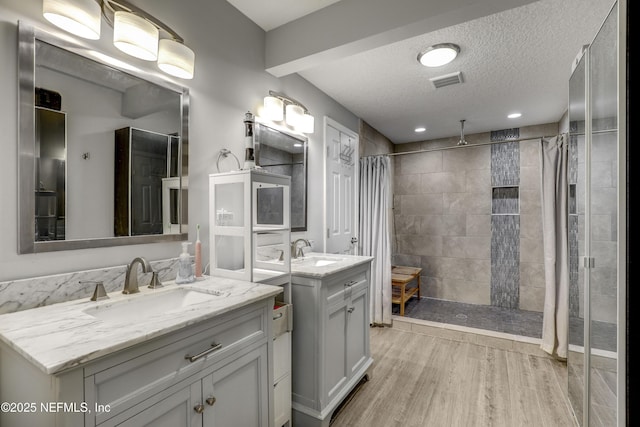 bathroom with wood-type flooring, a shower with shower curtain, a textured ceiling, and vanity