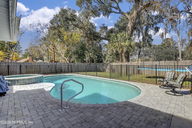 view of swimming pool featuring a patio area and an in ground hot tub