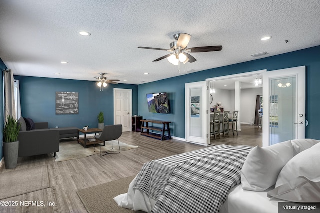 living room with dark wood-type flooring, ceiling fan, a textured ceiling, and a wealth of natural light