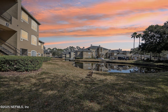 dock area with a water view and a yard