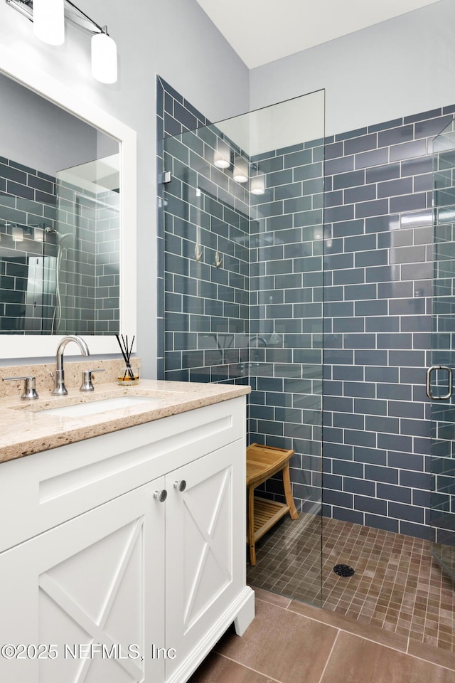 bathroom featuring tile patterned flooring, vanity, and a shower with shower door