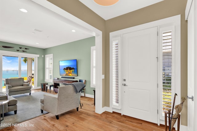 entrance foyer featuring light hardwood / wood-style floors and a water view