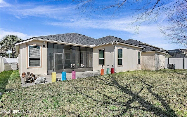 back of property featuring a sunroom, a yard, central AC, and a patio area