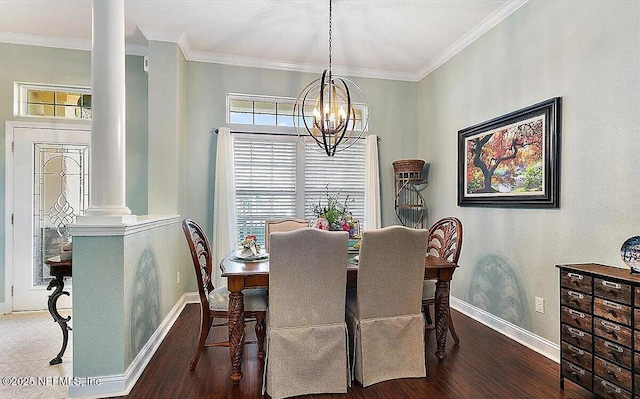 dining space featuring hardwood / wood-style floors, crown molding, decorative columns, and a chandelier