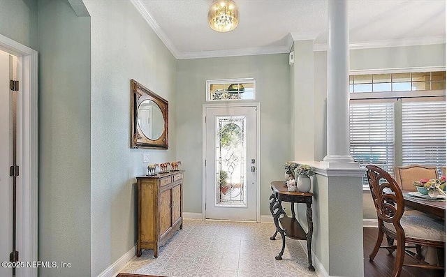 foyer with ornamental molding, a wealth of natural light, and decorative columns