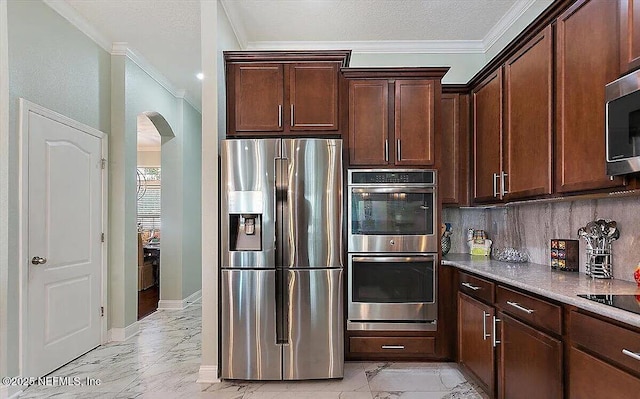 kitchen with tasteful backsplash, ornamental molding, light stone counters, stainless steel appliances, and dark brown cabinets