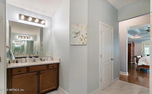 bathroom with beam ceiling, vanity, coffered ceiling, and a textured ceiling