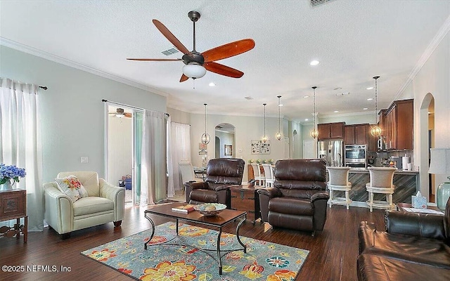 living room with crown molding, dark wood-type flooring, ceiling fan, and a textured ceiling