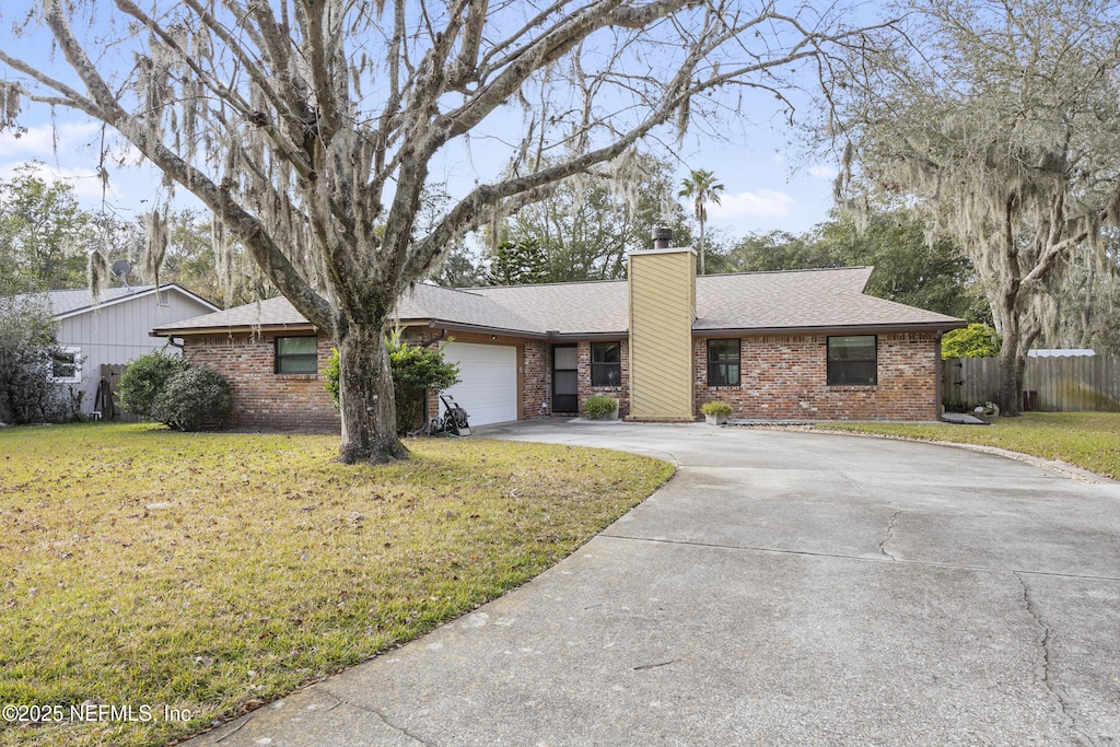 single story home featuring a garage and a front yard