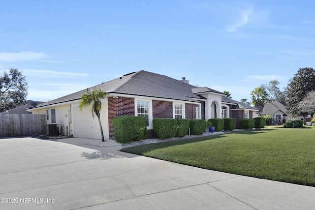 view of side of property with central AC unit and a yard