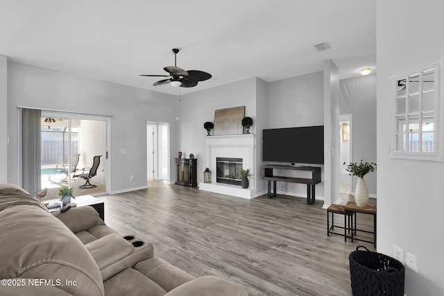 living room featuring ceiling fan, a high ceiling, and hardwood / wood-style floors