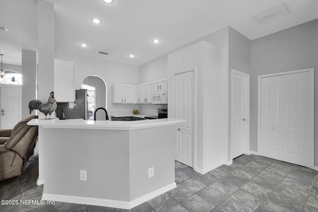 kitchen with sink, white cabinetry, appliances with stainless steel finishes, and kitchen peninsula